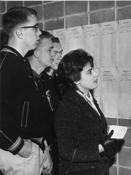 Photograph of students looking at examination lists