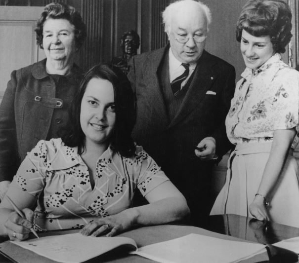 Photograph of contract signing between the Dalhousie Staff Association and the Board of Governors, 2 May 1975. L. to r., Mrs. H.A. MacDonald, Board; Mrs. Enid Jimenez, President DSA; President Hicks; Suzanne Jodrey, secretary DSA.